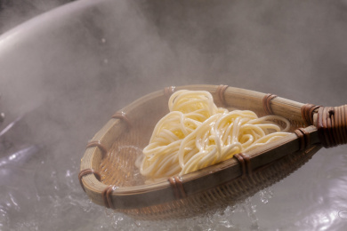 竹箕在大锅中捞起热腾腾的面