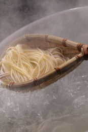 竹箕在大锅中捞起热腾腾的面