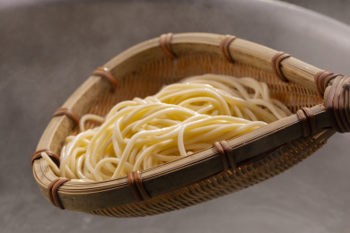 竹箕在大锅中捞起热腾腾的面