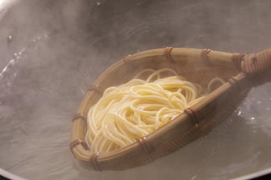 竹箕在大锅中捞起热腾腾的面