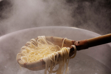 竹箕在大锅中捞起热腾腾的面