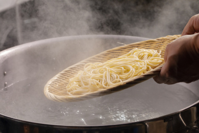 竹箕在大锅中捞起热腾腾的面