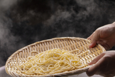竹箕在大锅中捞起热腾腾的面