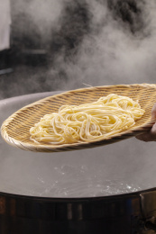 竹箕在大锅中捞起热腾腾的面