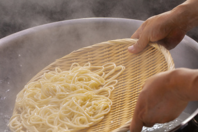 竹箕在大锅中捞起热腾腾的面