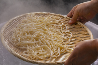 竹箕在大锅中捞起热腾腾的面