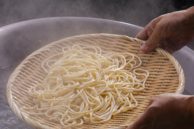 竹箕在大锅中捞起热腾腾的面