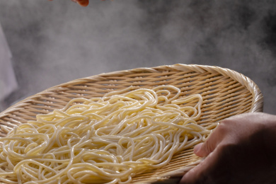 竹箕在大锅中捞起热腾腾的面
