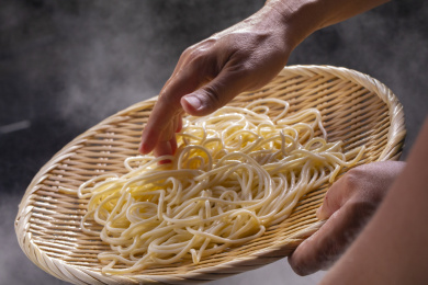 竹箕在大锅中捞起热腾腾的面