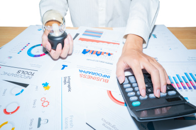 一个会计师正在按动计算器进行办公分析图表数据