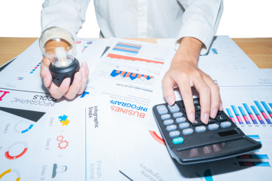 一个会计师正在按动计算器进行办公分析图表数据