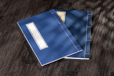 窗影下的桌面上摆放着传统线装书与青花盖碗