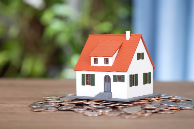 放在一堆美元硬币上的小房子模型