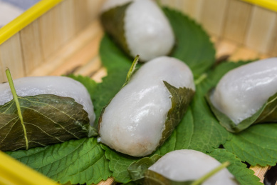 在紫砂壶和书法的中国风背景前有一盘中式小吃苏耗子