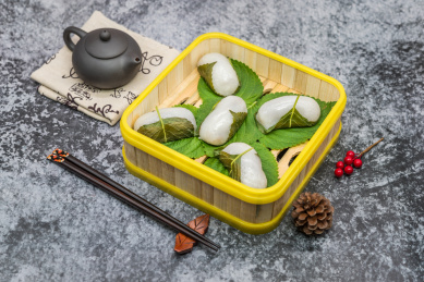 在紫砂壶和书法的中国风背景前有一盘中式小吃苏耗子