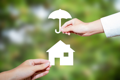 一个人手拿着雨伞另一个人手拿着剪纸保险保障平安概念