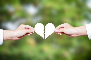 两个人手拿着破裂的心象征着分手分开离婚婚姻爱情破碎概念