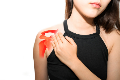一个女孩年轻人抚摸着自己疼痛的肩膀五十肩肩关节肩