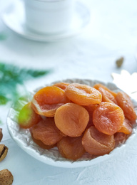 浅色背景下的多个杏干盘装于白色碟盘