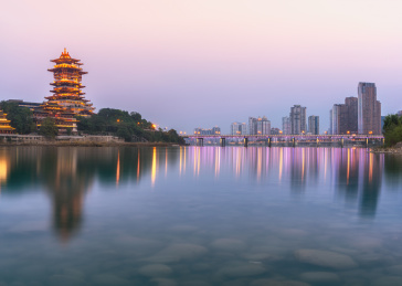 中国四川省绵阳市涪江畔的越王楼仿古建筑和城市现代建筑夜景和江里的倒影