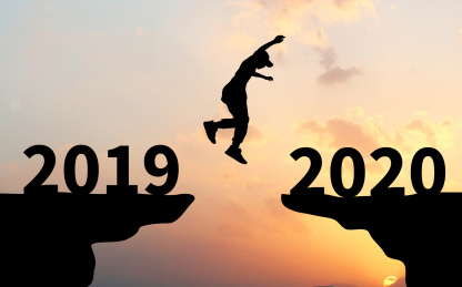 夕阳下背光剪影的山崖上一个剪影的人从2019年一端跳向2020一端