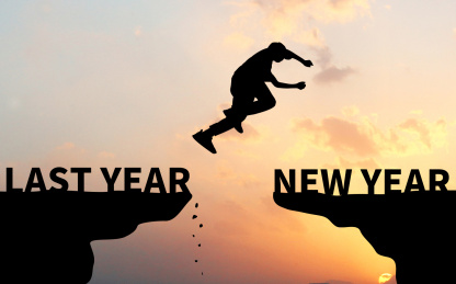 黄昏夕阳下剪影效果的悬崖上一个人从过去跳到新年