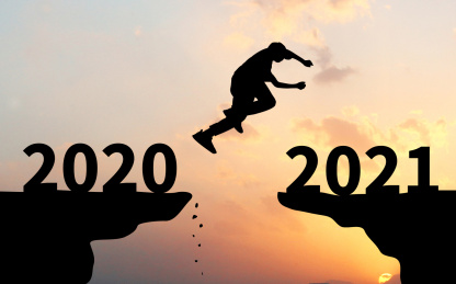 夕阳下背光剪影的山崖上一个剪影的人从2020年一端跳向2021一端