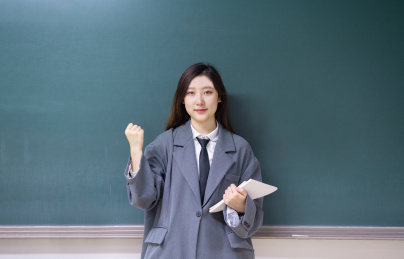 一个美女老师教室站在讲台前拿着书握拳加油鼓励鼓气教育概念
