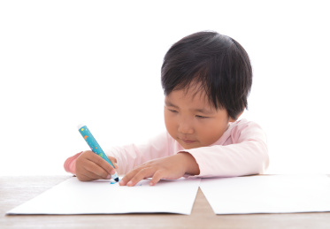 白背景前趴在桌子上认真画画的小女孩