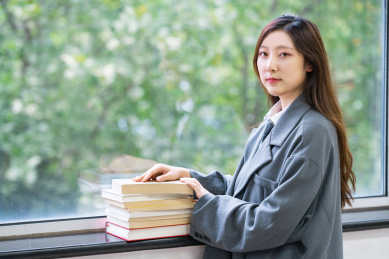 一个阳光美女大学生校花在图书馆窗户边看着书备考学习奋斗努力的学霸穿着校服读书阅读看书