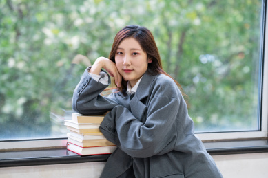 一个阳光美女大学生校花在图书馆窗户边看着书备考学习奋斗努力的学霸穿着校服读书阅读看书