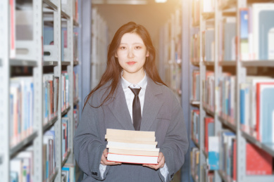 美丽的中国人美女正在图书馆认真的看着书籍书本阅读学习查询资料文献看书读书