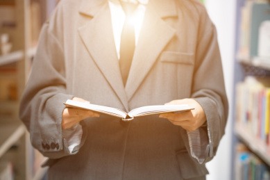 美丽的中国人美女正在图书馆认真的看着书籍书本阅读学习查询资料文献看书读书