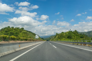 蓝天白云下穿过山区的主干线高速公路