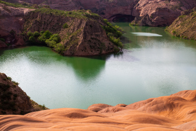 中国陕西省延安市波浪谷水上丹霞山谷间一汪绿水
