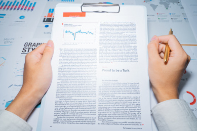 一个商务金融人士手拿着报表图表进行分析解析计算概念