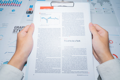 一个商务金融人士手拿着报表图表进行分析解析计算概念