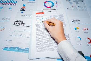 一个商务金融人士手拿着报表图表进行分析解析计算概念