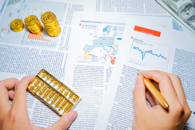 金融人士手里拿着钢笔指着商务市场经济图表报表报告进行分析办公研究