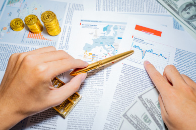 金融人士手里拿着钢笔指着商务市场经济图表报表报告进行分析办公研究