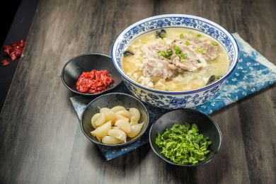 棕色木纹桌面上放着一份羊肉泡馍套餐