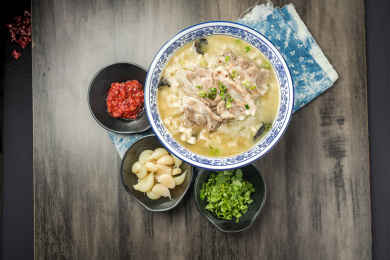 棕色木纹桌面上放着一份羊肉泡馍套餐