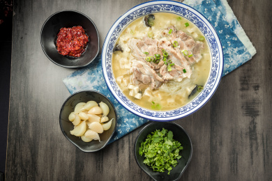 棕色木纹桌面上放着一份羊肉泡馍套餐