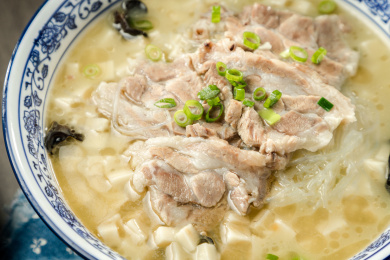 棕色木纹桌面上放着一份羊肉泡馍套餐