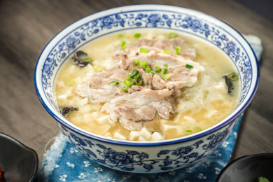 棕色木纹桌面上放着一份羊肉泡馍套餐