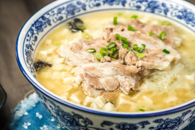 棕色木纹桌面上放着一份羊肉泡馍套餐