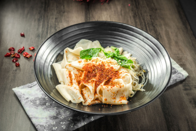 棕色木纹桌面上放着一份油泼拌面