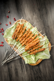 棕色木纹桌面上放着一把烤羊肉串