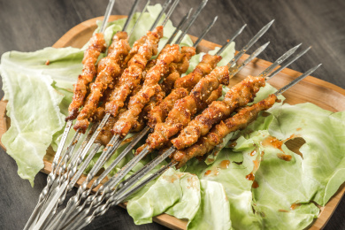 棕色木纹桌面上放着一把烤羊肉串