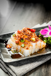 棕色木纹桌面上放着一盘酸辣凉粉